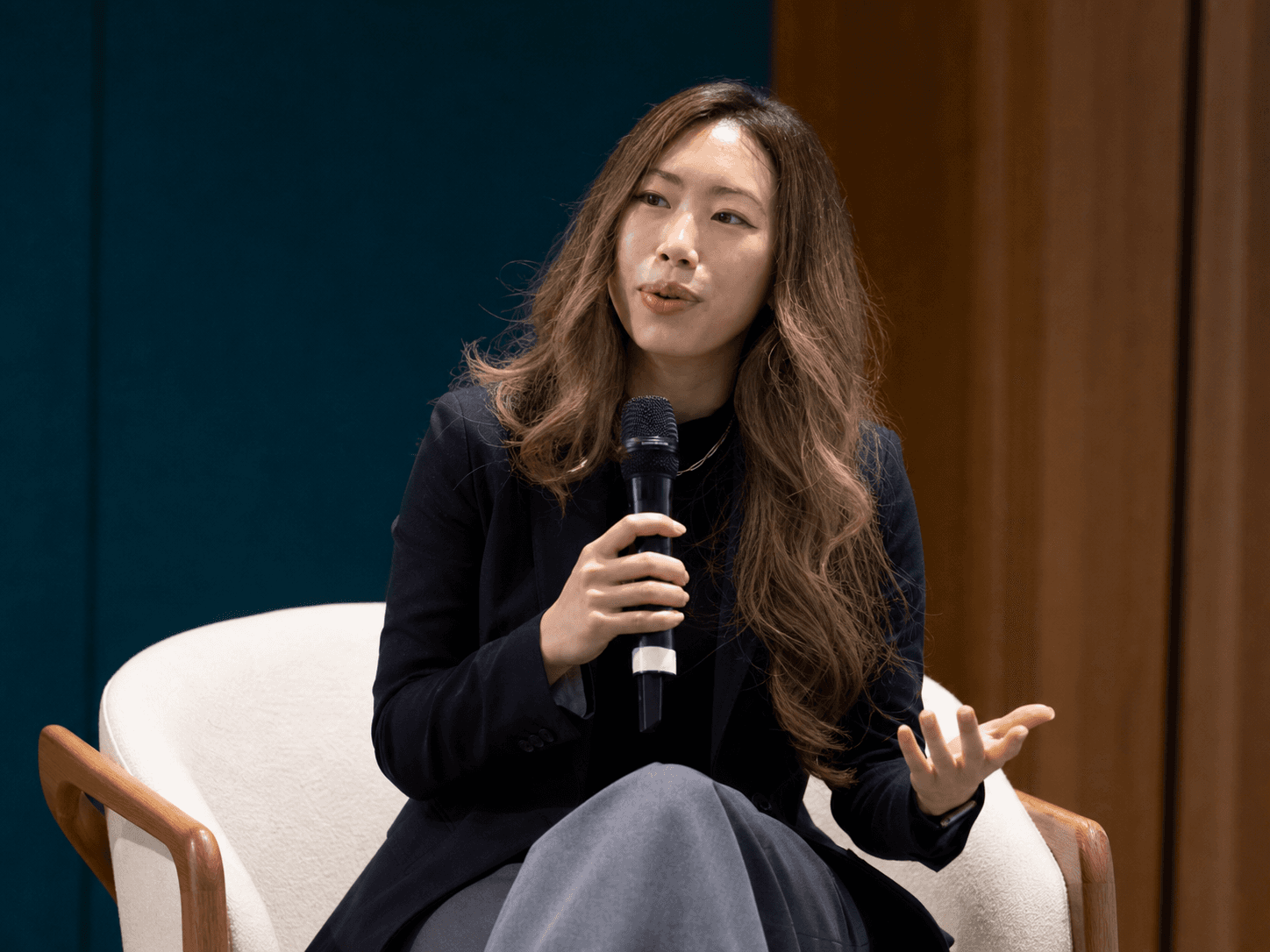 Hillary Lin, MD speaking with a handheld microphone onstage