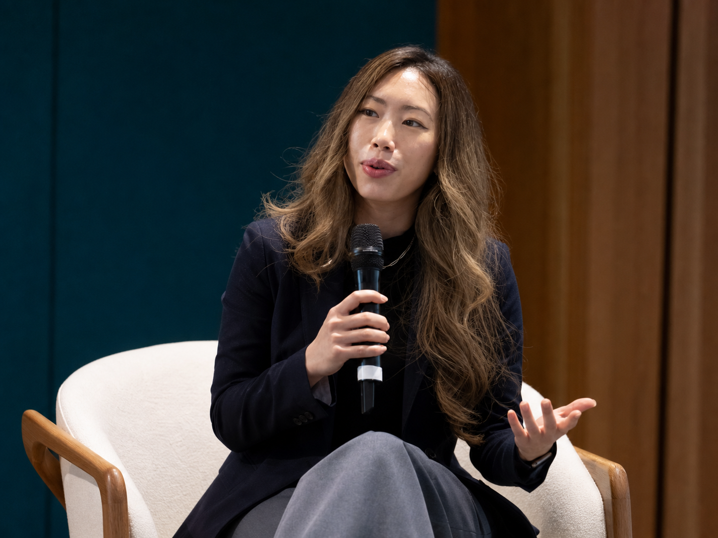 Hillary Lin, MD speaking with a handheld microphone onstage