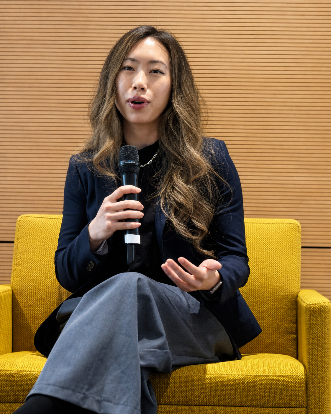 Hillary Lin, MD speaking from a yellow chair onstage